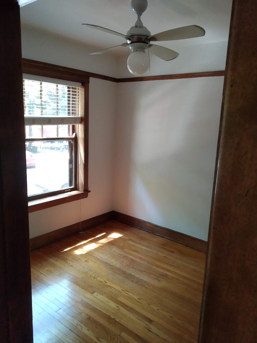 an empty room with a ceiling fan and a window