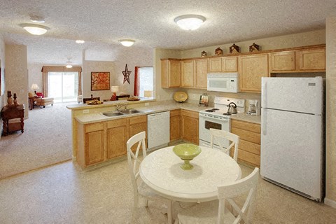 A kitchen with a white table and chairs.
