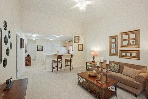 A living room with a couch, coffee table, and pictures on the wall.
