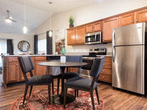 A kitchen with a table and chairs.