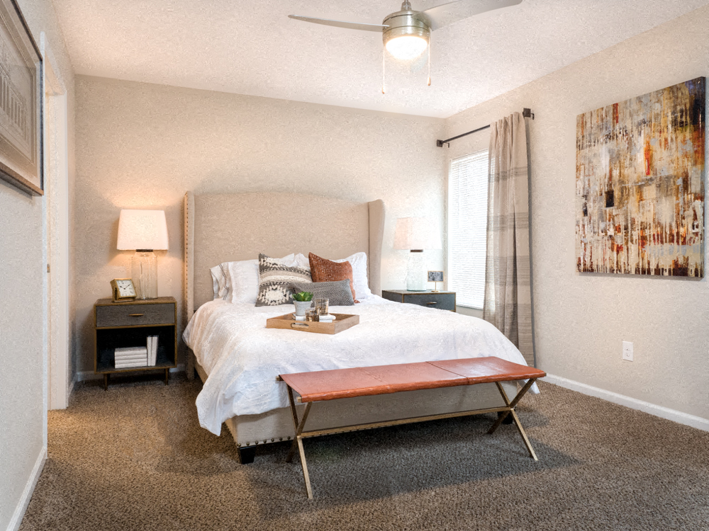 A bedroom with a large bed and a painting on the wall.