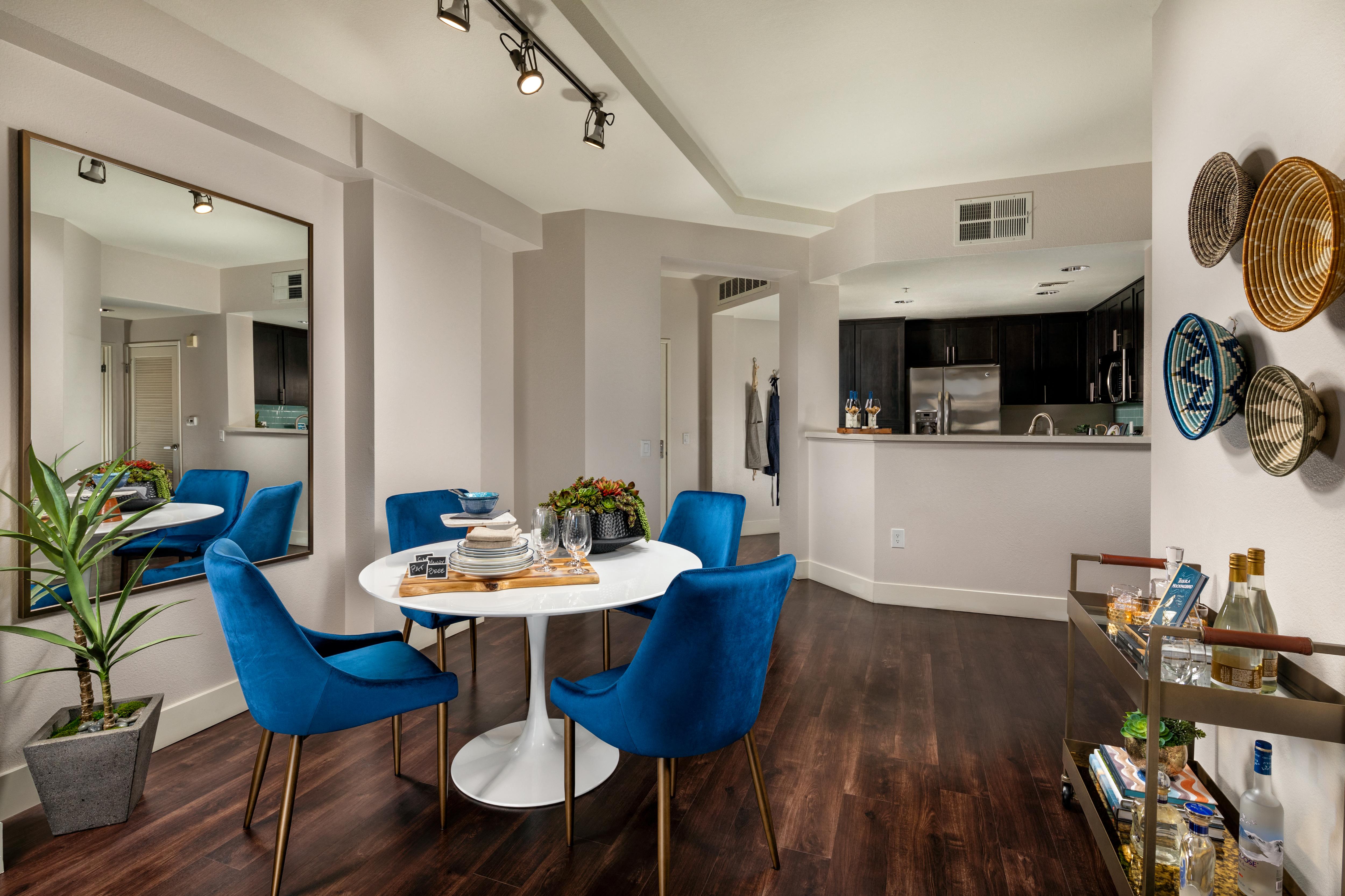 A dining room with a white table and blue chairs.