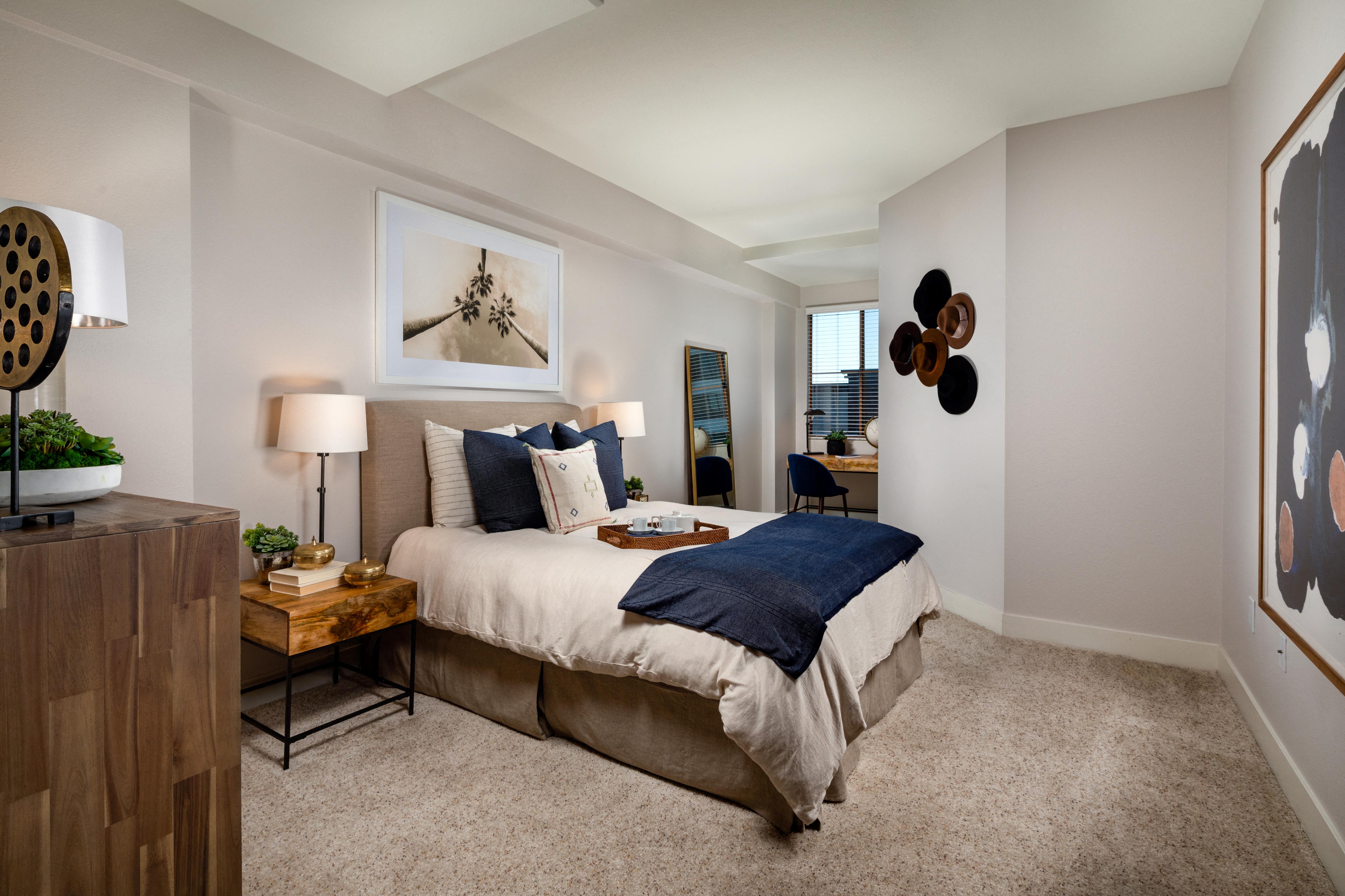 A bedroom with a bed, nightstand, and lamp.
