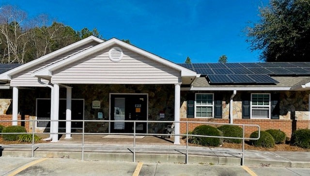 the front of a building with solar panels on the roof