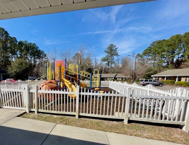 a white picket fence in front of a playground