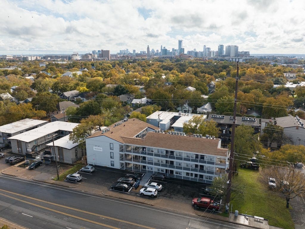 an aerial view of a building with a city in the background