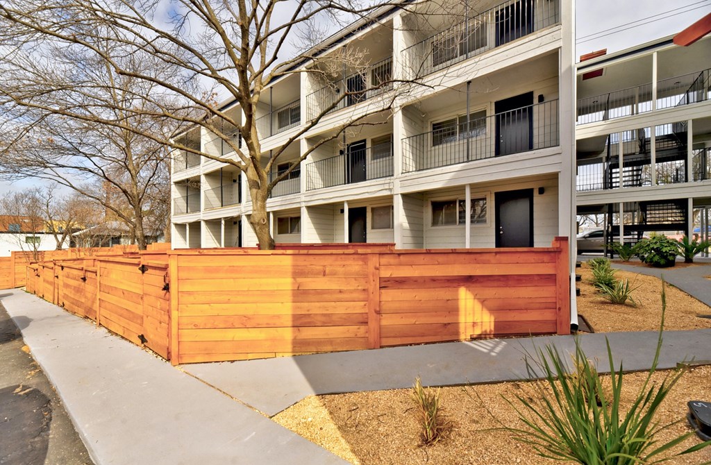 a wooden fence in front of an apartment building