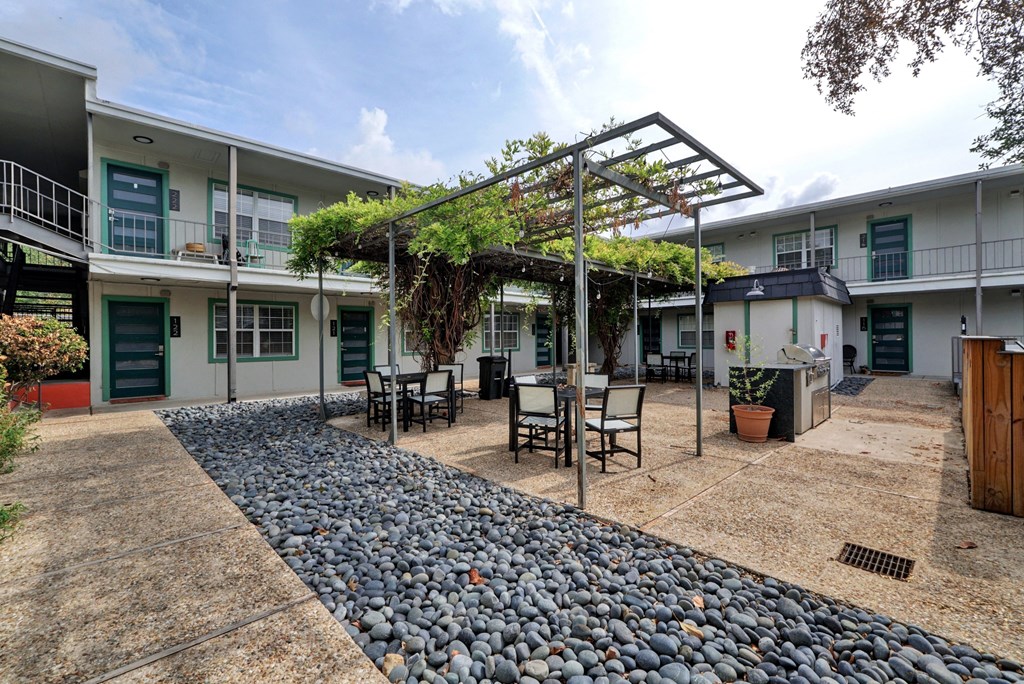 a patio with tables and chairs in front of a building