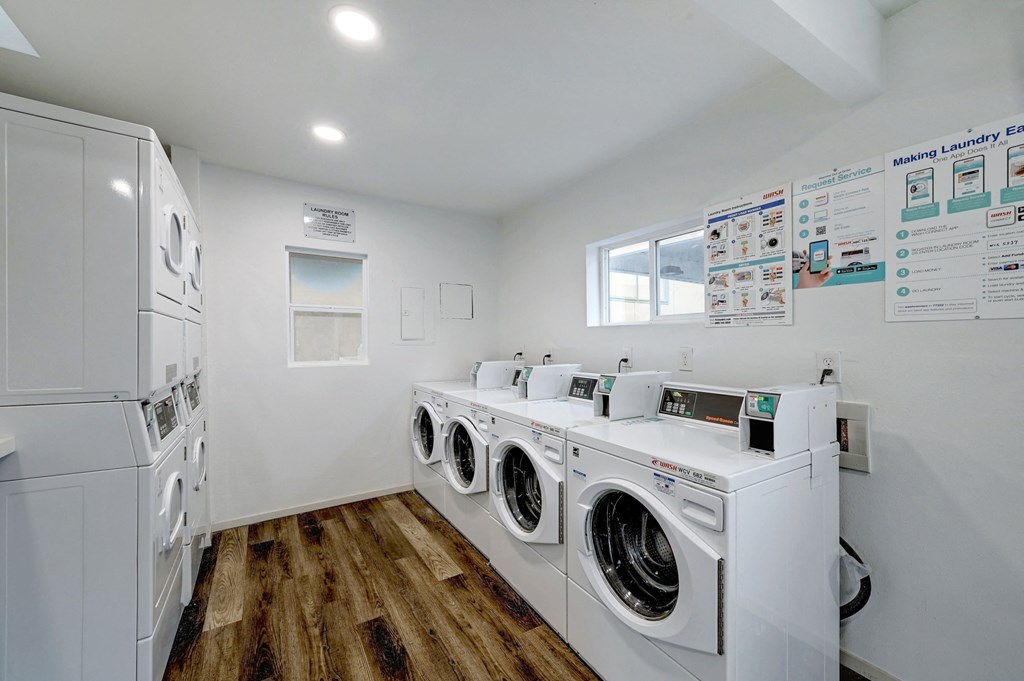a washer and dryer room with laundry machines and a window