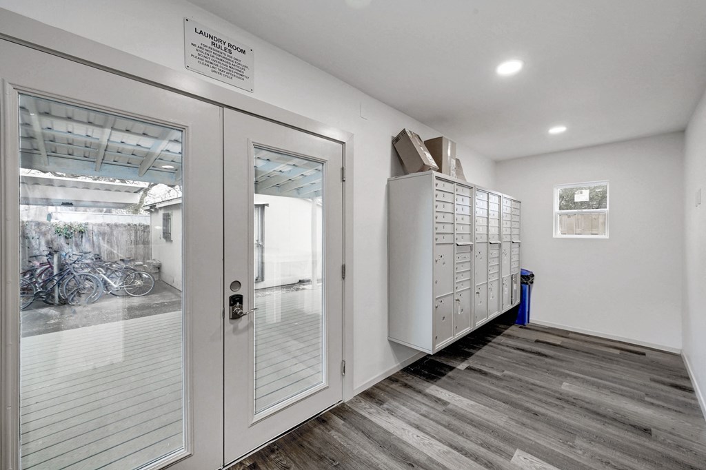 the entrance to a laundry room with white walls and glass doors