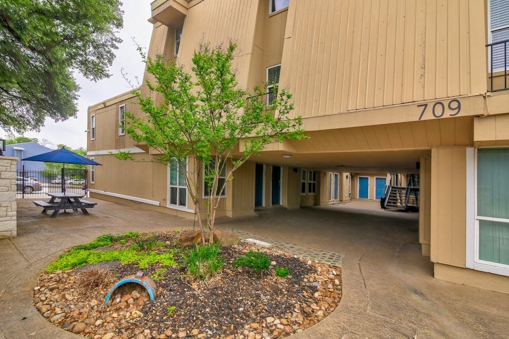 a tree in the center of a courtyard in front of a building