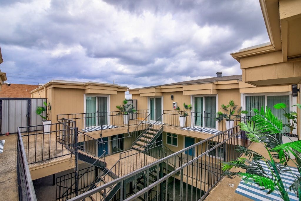 a building with stairs and balconies and a cloudy sky