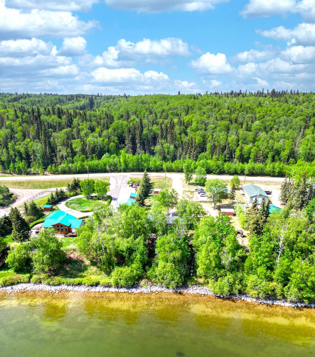 an aerial view of a resort with a body of water and trees