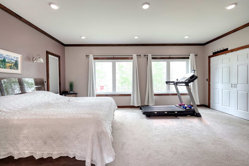 a bedroom with a bed and a treadmill