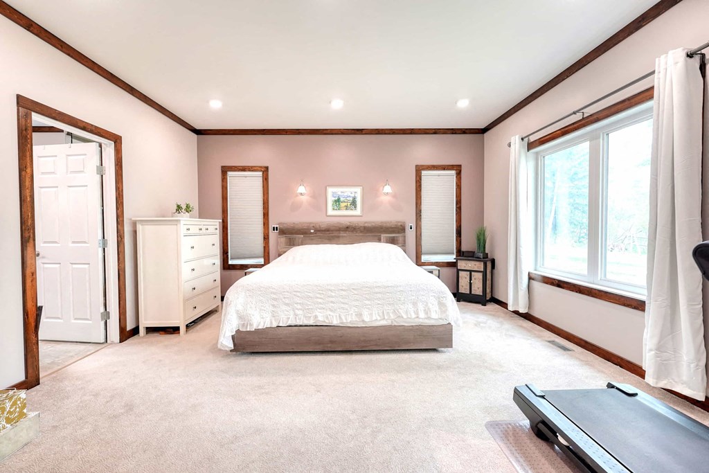 a bedroom with a bed and two windows