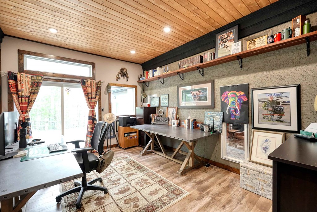 a home office with a desk and a large window