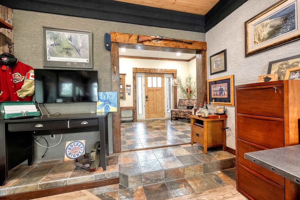 a living room with a tv and a hall way with a door