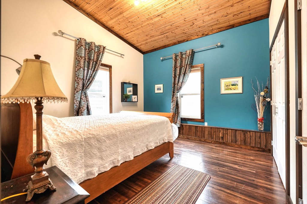 a bedroom with a bed and blue walls and a wooden floor