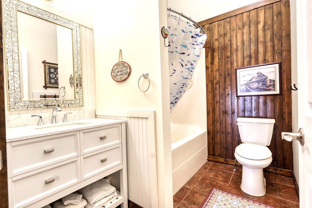 a bathroom with a toilet and a shower and a sink
