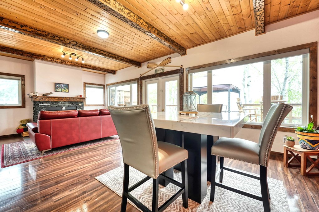 a dining room table with chairs and a living room with a red couch