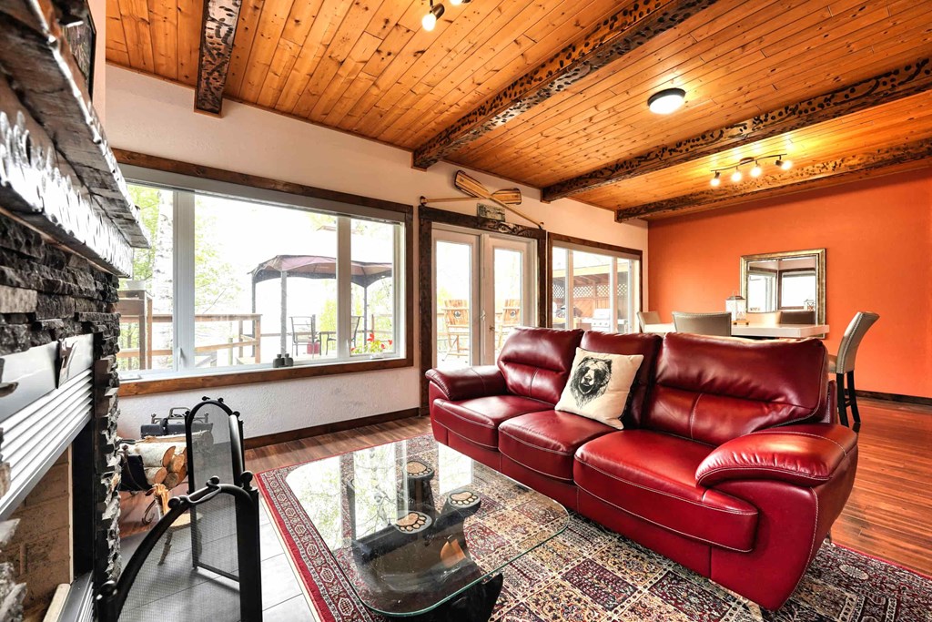 a living room with a red leather couch and a fireplace