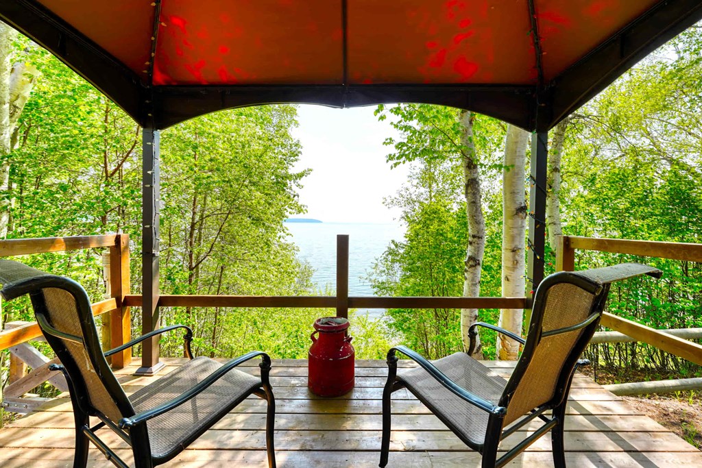 a porch with chairs and a view of the water