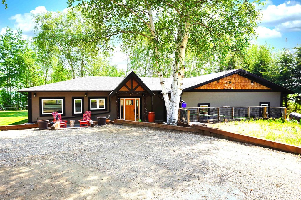 a house with a driveway and a tree in front of it
