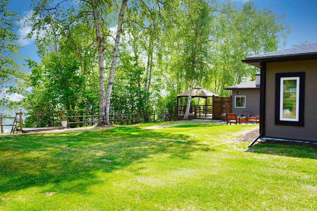 a backyard with a house and a gazebo in the trees