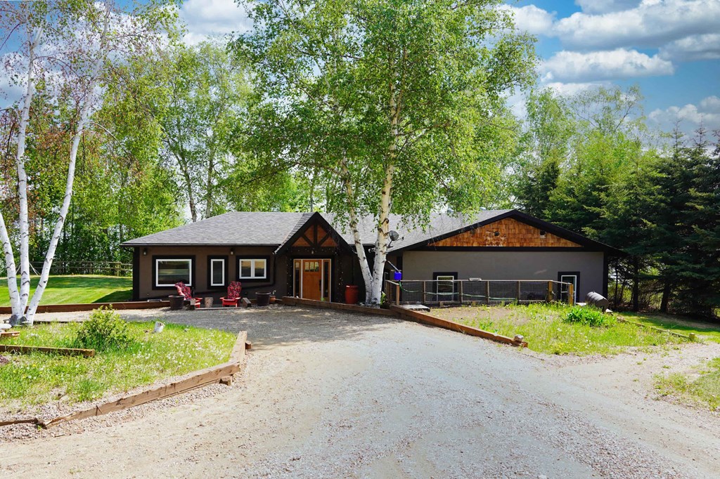 a view of the front of a house with a gravel driveway