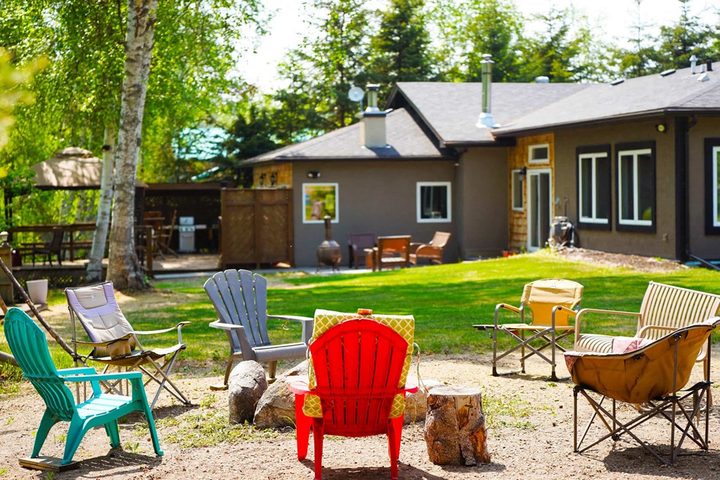 a yard with chairs and a house in the background