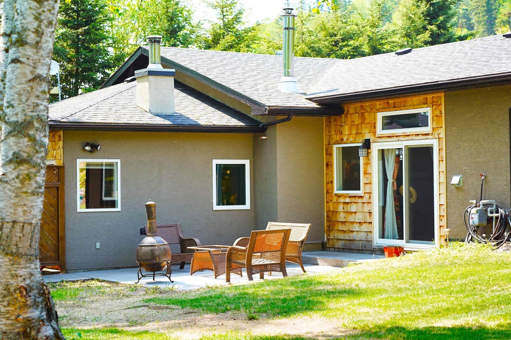 a patio in front of a house with a table and chairs