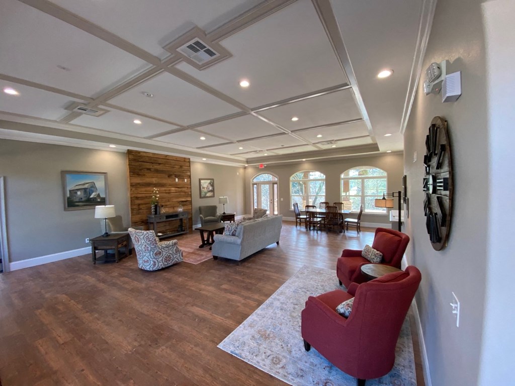 a large living room with red chairs and a white pillar