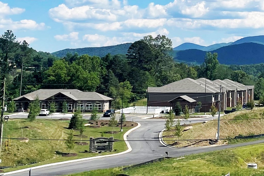 an aerial view of a building with mountains in the background