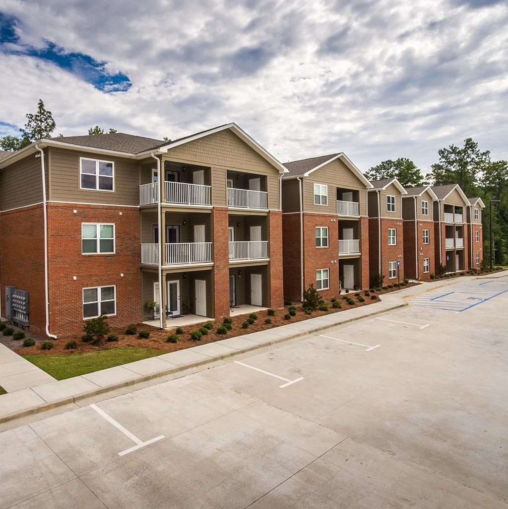an empty parking lot in front of an apartment building