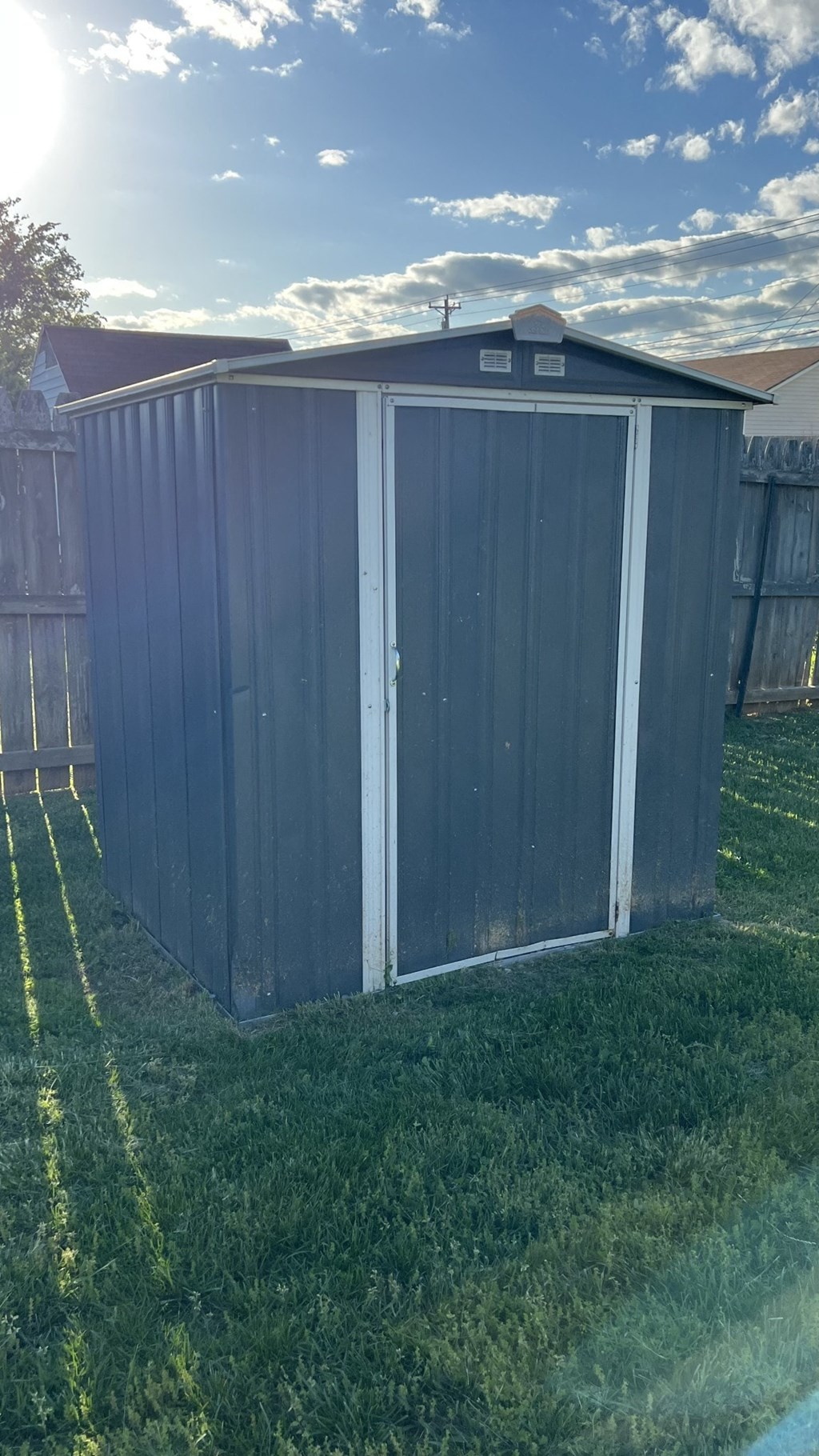 a small shed in the grass in a backyard