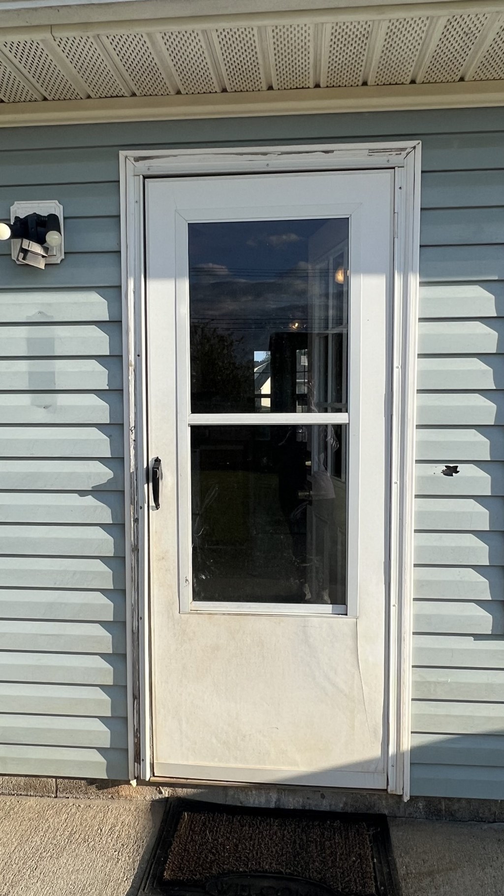 a white door on the side of a blue house