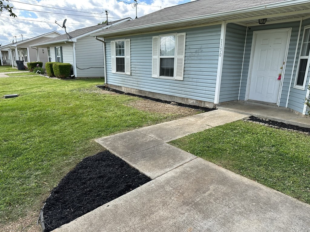 a sidewalk in front of a blue house