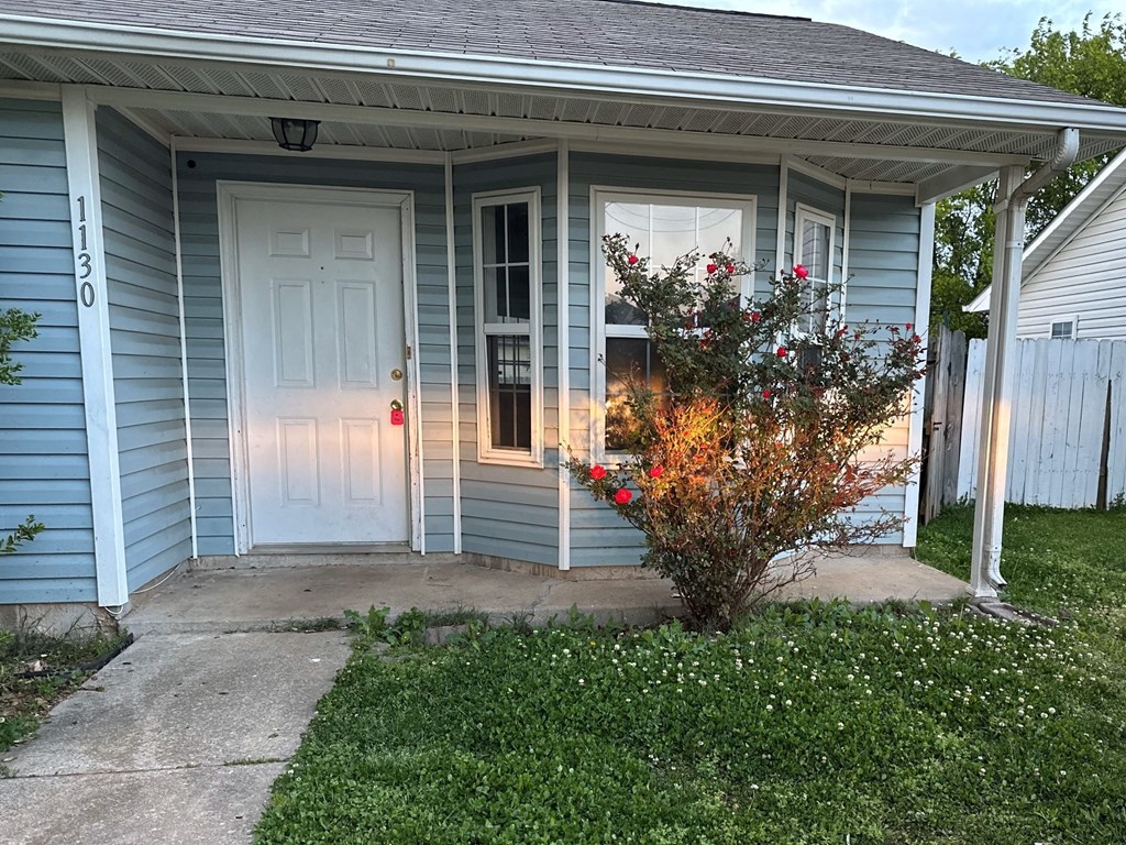 the front of a blue house with a white door