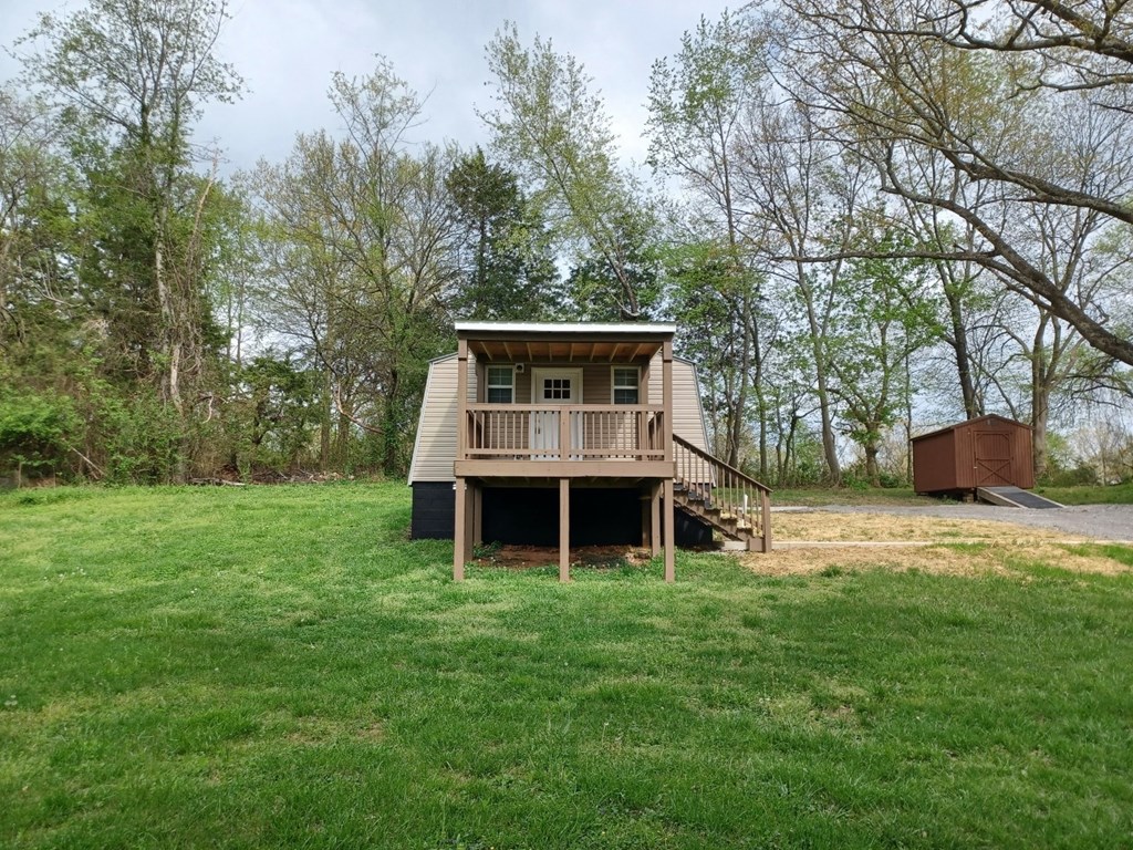 the cabin is on a hill in the middle of a field