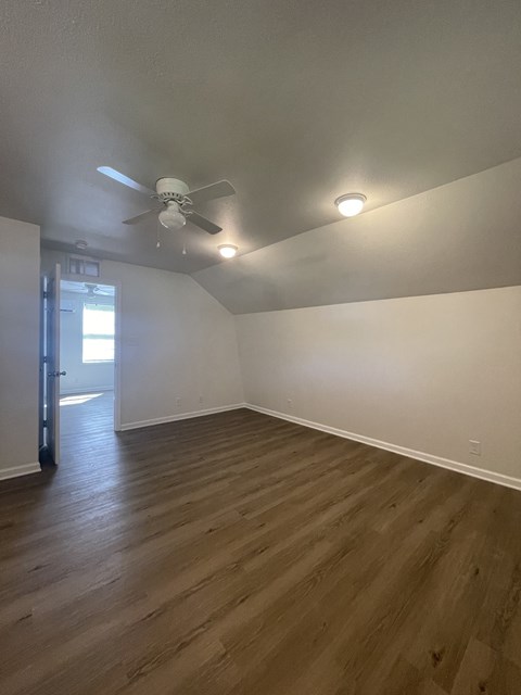 a living room with white walls and a ceiling fan