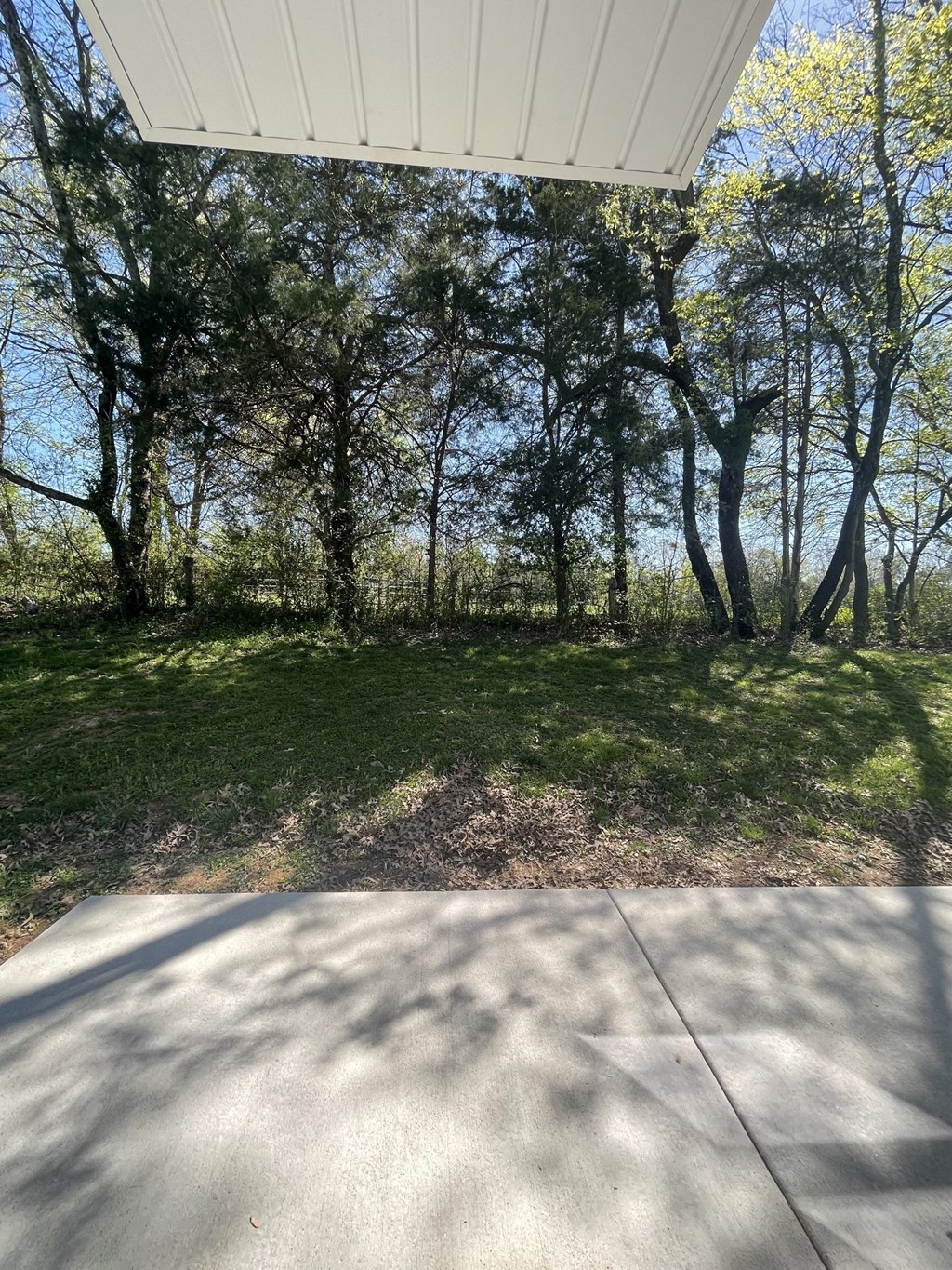 a view of the grass and trees from a porch