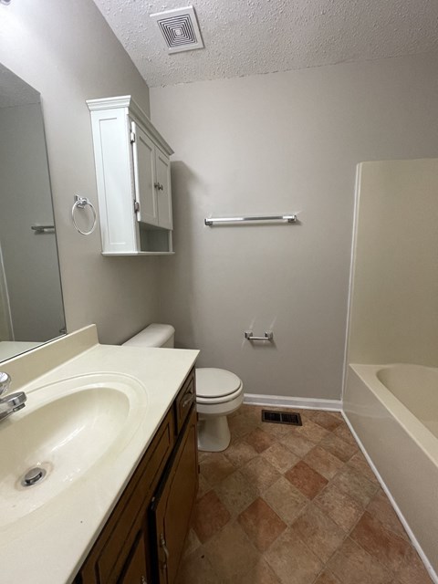 A bathroom with a sink, toilet, and bathtub.