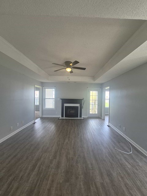 A spacious room with a fireplace and a ceiling fan.