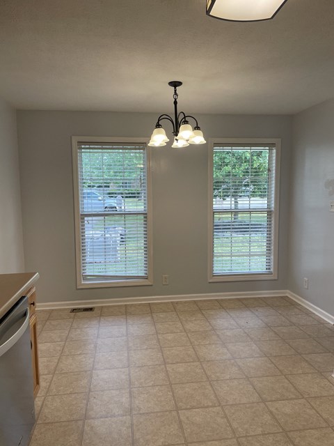 A kitchen with a dishwasher and a chandelier.