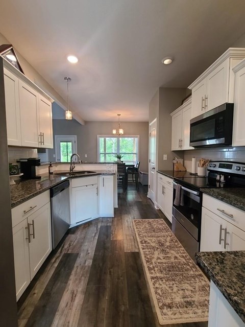 A kitchen with white cabinets and a black stove top oven.