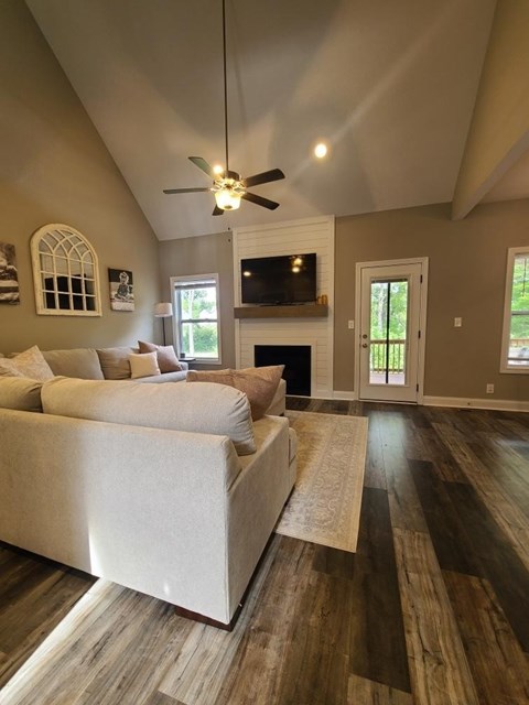 A living room with a white couch and a ceiling fan.