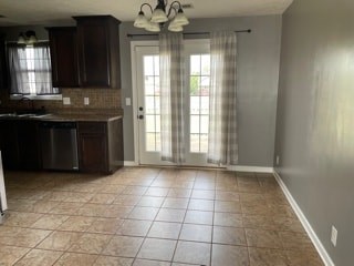 A kitchen with brown tile flooring and a white door.