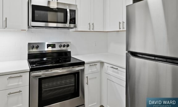 a white kitchen with a stove microwave and refrigerator