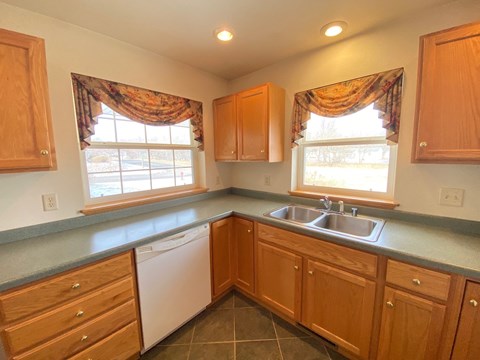 a kitchen with wooden cabinets and a sink and a window