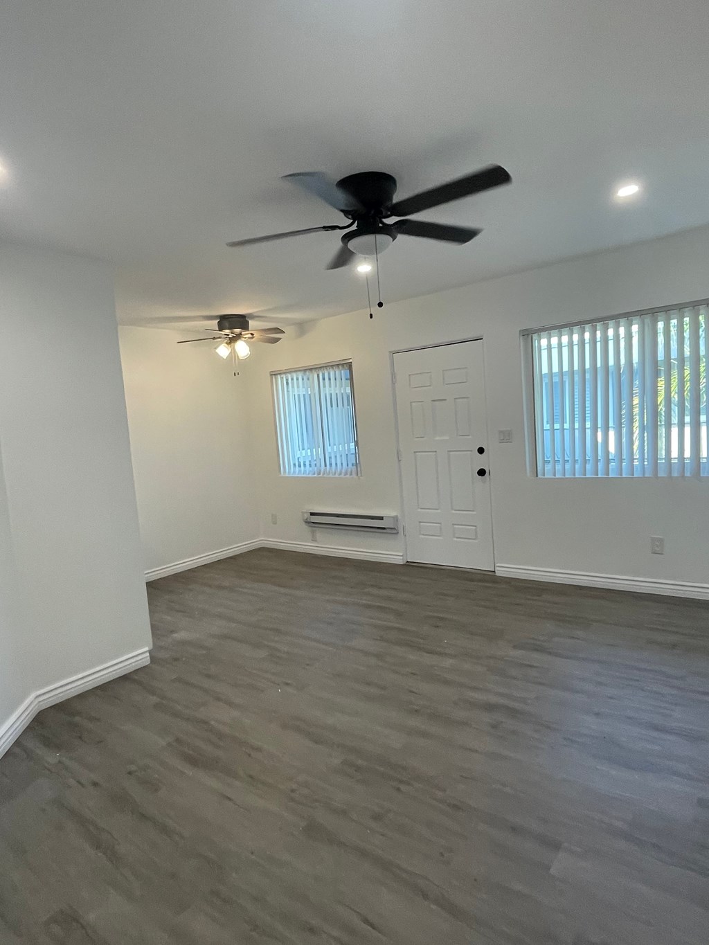 A room with a ceiling fan and light fixture.